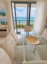 Floor-to-ceiling sliding glass door, metal balcony railing, and ocean backdrop