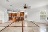Open-concept kitchen featuring custom wood cabinetry, an expansive center island with pendant lighting, stone flooring with decorative inlay, and rece