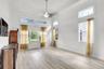 High ceilings with crown molding, wood-finish flooring, transom windows, and a central ceiling fan