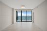 Living space featuring large-format tile flooring, floor-to-ceiling glass sliding doors, and a private balcony with water frontage