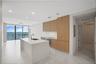 Kitchen featuring an island with a stone countertop, flat-panel wood cabinetry, integrated appliances, recessed lighting, and large-format tile floori