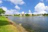 Waterfront parcel featuring a manicured lawn, lake, and integrated water fountain