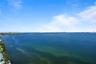 Elevated coastal perspective featuring expansive open water, a distant causeway, and a metropolitan skyline