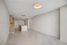 Open-concept interior featuring light-toned tile flooring, custom wood-finish cabinetry, a central kitchen island with a neutral countertop, and a mod