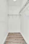 Storage space featuring wood-finish flooring and integrated wire shelving