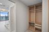 Built-in closet featuring light-toned cabinetry, two storage drawers, and hanging rods
