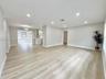 Open interior featuring wood-finish flooring, recessed lighting, and kitchen cabinetry with built-in wine storage