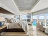 Floor-to-ceiling windows, stone tile flooring, built-in recessed ceiling lighting with textured inlay, and wall-mounted electric fireplace