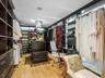 Custom dark wood-finish cabinetry, floor-to-ceiling built-in shelving, central island storage, integrated LED task lighting, and hardwood flooring