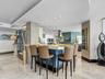 Custom kitchen island with a stone-finish countertop and blue cabinetry, textured stone accent pillar, recessed ceiling lighting, and polished stone f