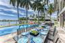 Outdoor waterfront Point Lot with pool area with outdoor dining, lounge chairs, BBQ & siting area.