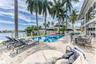 Outdoor waterfront Point Lot with pool area with outdoor dining, lounge chairs, BBQ & siting area.