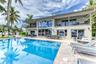 Outdoor waterfront Point Lot with pool area with outdoor dining, lounge chairs, BBQ & siting area.