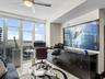 Floor-to-ceiling windows, built-in black cabinetry, stone flooring, and a ceiling fan with integrated lighting
