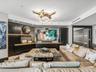 Custom built-in dark cabinetry with integrated shelving, stone-finish feature wall, and sculptural modern chandelier