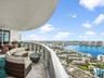 Expansive curved balcony featuring stone flooring and a glass railing
