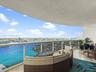 Covered terrace featuring polished stone flooring and glass panel railing