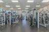 Fitness center featuring rubber flooring, recessed ceiling lighting, multiple ceiling fans, and an array of weight training and cardio equipment