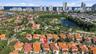 Aerial perspective of residential community featuring tiled roofs, manicured landscaping, integrated water features, and proximity to the coastline