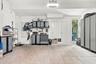Finished garage featuring integrated wall-mounted storage panels, custom built-in cabinetry with metal-finish doors, durable concrete flooring, and a 