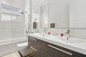 Floating dual-sink vanity with wood-finish cabinetry, rectangular under-mount sinks, and polished chrome faucets