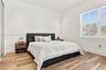 Bedroom featuring wood-finish flooring, recessed lighting, and a window with horizontal blinds