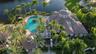 Aerial perspective featuring a clubhouse with a tiled hip roof, a paved pool deck, a swimming pool with a central island, a detached gazebo, and exten