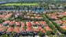 Aerial perspective featuring a two-story residence with a clay tile roof, private swimming pool, and concrete driveway