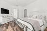 Room interior featuring wood-finish flooring, recessed lighting, and an arched doorway