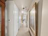Hallway featuring large-format tile flooring, multi-panel doors, and adjustable track lighting