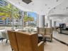 Floor-to-ceiling windows, recessed lighting, stone flooring, and built-in service counter