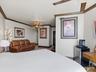 Vaulted ceilings with crown molding, decorative chandelier, and ceiling fan
