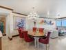 Living space featuring stone tile flooring, crown molding, a decorative crystal chandelier, and adjustable track lighting