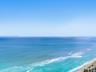 Expanse of ocean horizon with a clear sky and sandy coastline