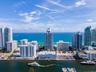 Aerial perspective featuring coastal high-rise architecture, direct water frontage, deep-water access, and horizon ocean scenery