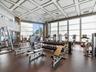 Fitness center featuring a coffered ceiling, floor-to-ceiling windows, and impact-resistant rubber flooring