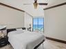 Stone flooring, expansive sliding glass doors, ceiling fan with light fixture, and crown molding