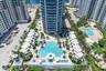 High-rise residential tower featuring a multi-level pool deck, multiple cabanas, palm tree landscaping, and paved hardscaping