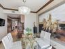 Dining area featuring crown molding, neutral wall finishes, stone tile flooring, and a decorative pendant light fixture