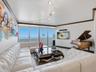 Floor-to-ceiling windows, curved track lighting, crown molding, and neutral wall-to-wall carpeting