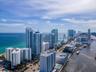 Aerial perspective featuring waterfront high-rise architecture, proximity to the Atlantic coastline, and maritime access along the canal