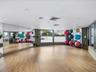 Fitness room featuring wood-finish flooring, full-length wall mirrors, recessed lighting, and expansive windows