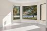 Expansive room featuring a multi-panel window bay, neutral wall finishes, recessed ceiling lighting, and large-format tile flooring