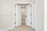 Double doors featuring horizontal panel detailing, matte black hinges, and matte black hardware, offset by neutral walls and light-toned flooring