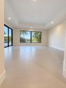 Interior space featuring large-format tile flooring, tray ceilings, recessed lighting, expansive glass sliding doors, and oversized windows