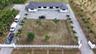 Single-story residence featuring a dark metal roof, expansive grounds, paved driveway, and perimeter fencing