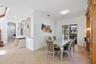 Dining area featuring diagonal tile flooring, built-in floor-to-ceiling wood cabinetry, decorative wall mirror with geometric inlay, and sliding glass