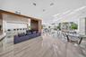 Living area featuring oversized sliding glass doors, a built-in dry bar with stone backsplash, large-format tile flooring, and integrated pendant ligh