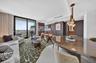 Full-height wall panels with textured light-gray finish, floor-to-ceiling mirror-finish cabinetry, porcelain tile flooring, and integrated ceiling tra
