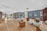 Open-concept living area featuring floor-to-ceiling glass sliding doors, stone-surfaced kitchen island, custom built-in cabinetry, and integrated arch